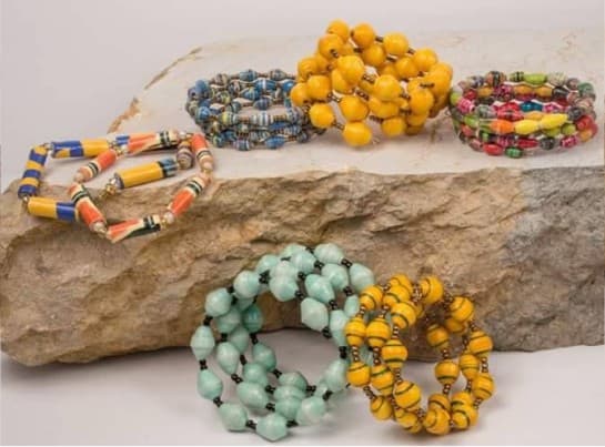 Umoja women stringing bead jewelry together