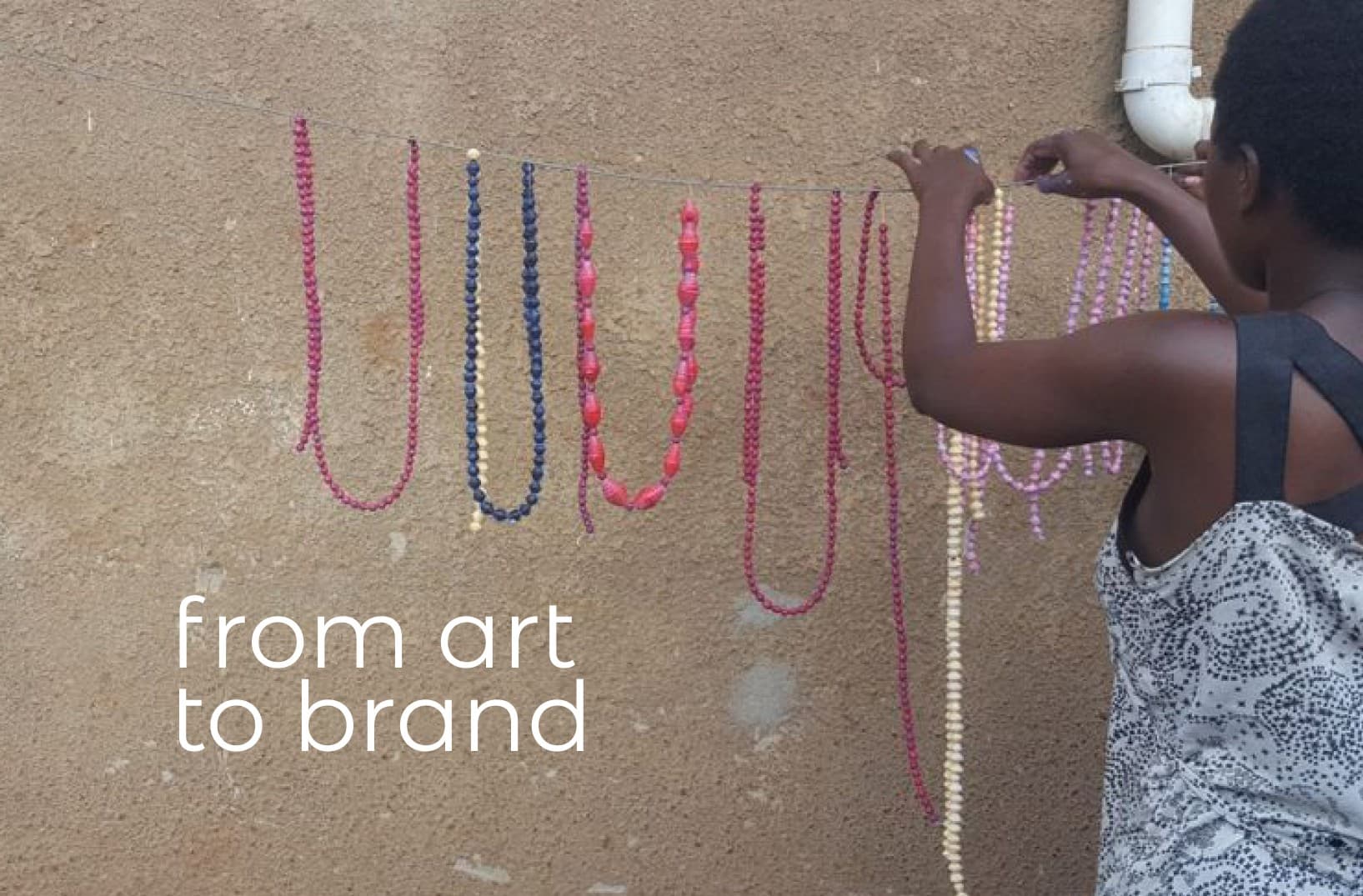Colorful beaded necklaces handcrafted by the Umoja women's group, captioned 'from art to brand'