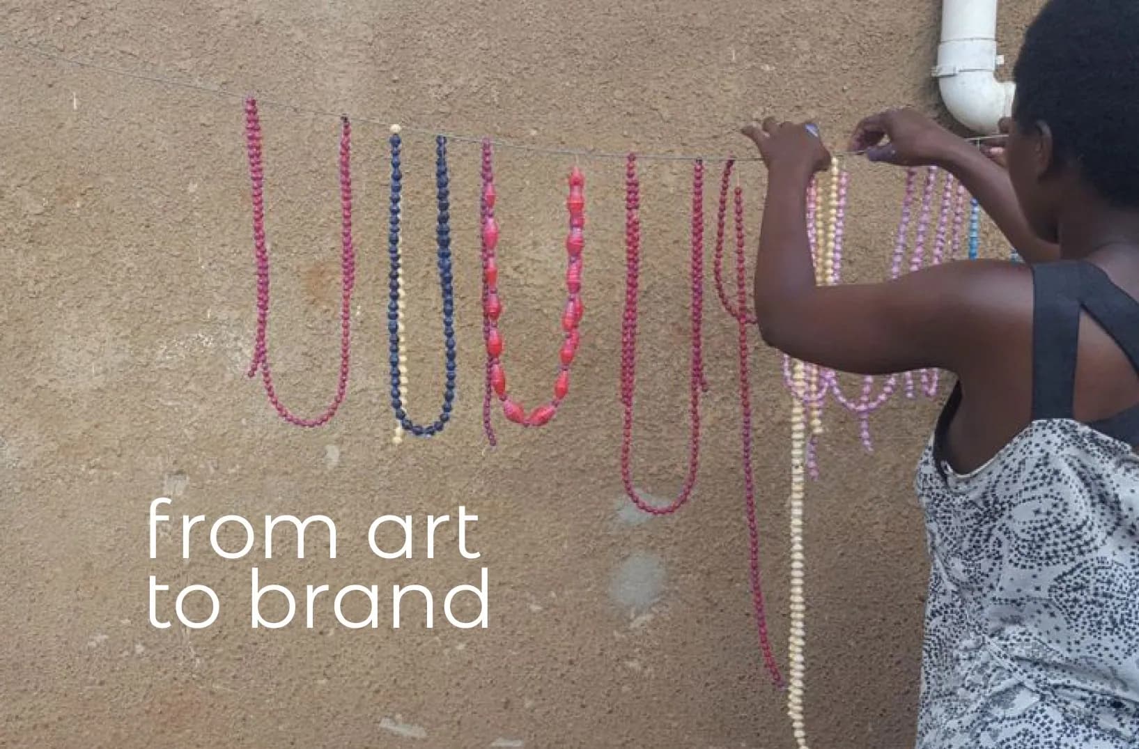 Colorful beaded necklaces handcrafted by the Umoja women's group, captioned 'from art to brand'